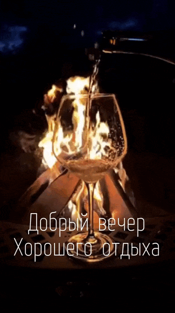 Вино наливают в бокал у костра